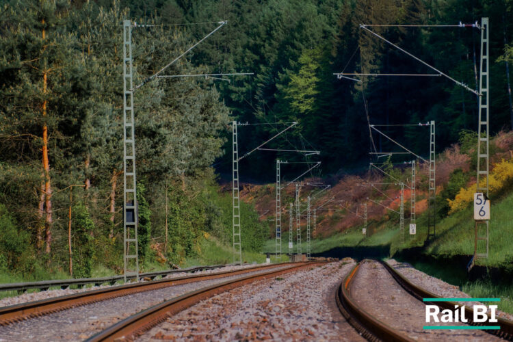 Railway line running through a tree-lined landscape, illustrating climate resilience planning in rail infrastructure